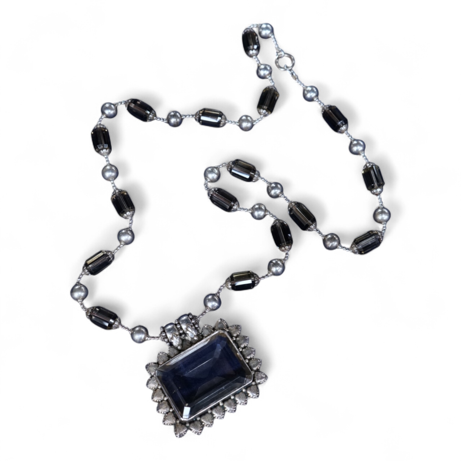 A white metal and quartz set drop pendant necklace, overall 90cm.
